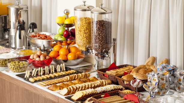 A buffet with various food items including fruits, pastries, and beverages. - Telioni (Thessaloniki)