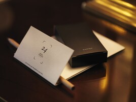 Musta laatikko, jonka päällä on teksti ”SLEEP KIT”, ja valkoinen kortti, jossa lukee ”24 ROYAL TERRACE” ja puhelinnumero.