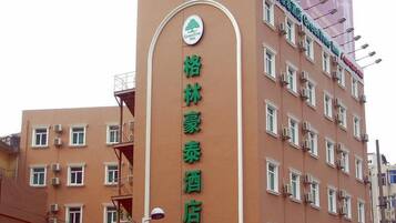 Un hotel con un letrero verde que indica que es un hotel GreenTree.