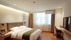 A hotel room with a large bed, bedside table with a phone, a desk with a chair, a TV mounted on the wall, and a window with curtains. - GreenTree Inn Jiujiang Railway Station Hotel (Jiujiang)