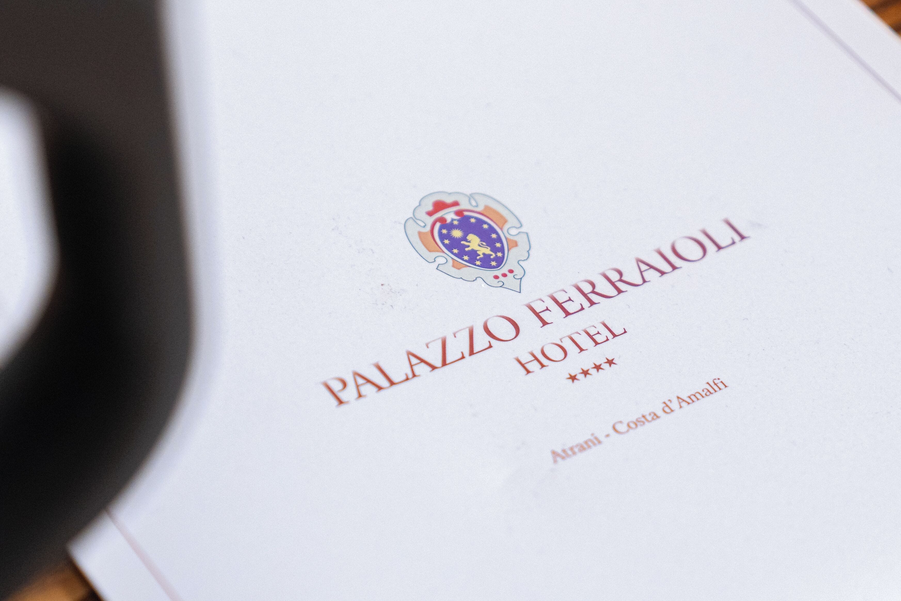 Letrero con el nombre del hotel, un escudo y la inscripción 'PALAZZO FERRAIOLI HOTEL'.