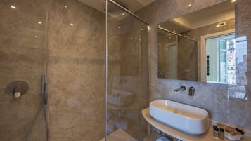 Une salle de bain moderne avec une douche à parois de verre, une baignoire sur pieds et un grand miroir.
