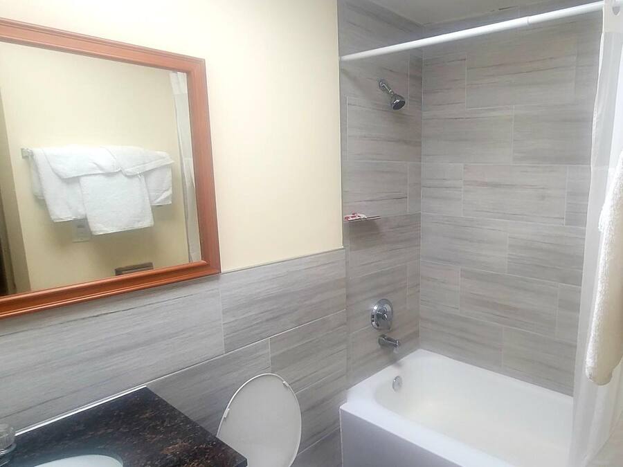 A bathroom with a bathtub, a shower, a toilet, and a sink.