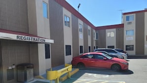 A parking area with a registration building, marked parking spaces, and a yellow curb.
