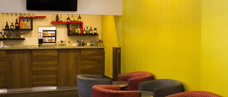 A bar area with seating and a television mounted on the wall.