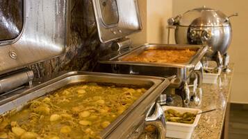 A buffet with various dishes, including a large pot and multiple serving trays.