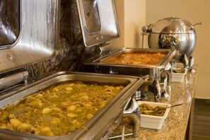 A buffet with various dishes, including a large pot and multiple serving trays.