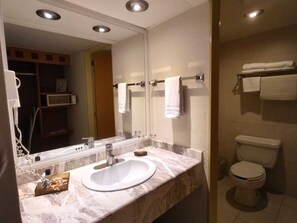 A bathroom with a white sink, mirror, and towel rack.