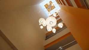 A modern interior with a geometric ceiling design and a central chandelier. - Hotel Mirabel (Querétaro)