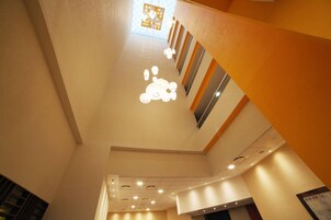 Interior de varios niveles con un diseño moderno, que incluye una lámpara central y una escalera.