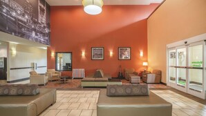A lobby with a large mural, comfortable seating, and a reception desk. - La Quinta Inn & Suites by Wyndham Smyrna TN - Nashville (Smyrna)