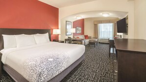 A hotel room with a large bed, a desk, a chair, a small table, and a TV. - La Quinta Inn & Suites by Wyndham Smyrna TN - Nashville (Smyrna)