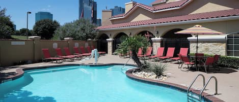 Alberca al aire libre, sombrillas en la alberca y camastros