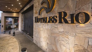 A stone wall with the words "HOTELES RIO" illuminated in the center. - Hotel Rio Tequisquiapan (Tequisquiapan)