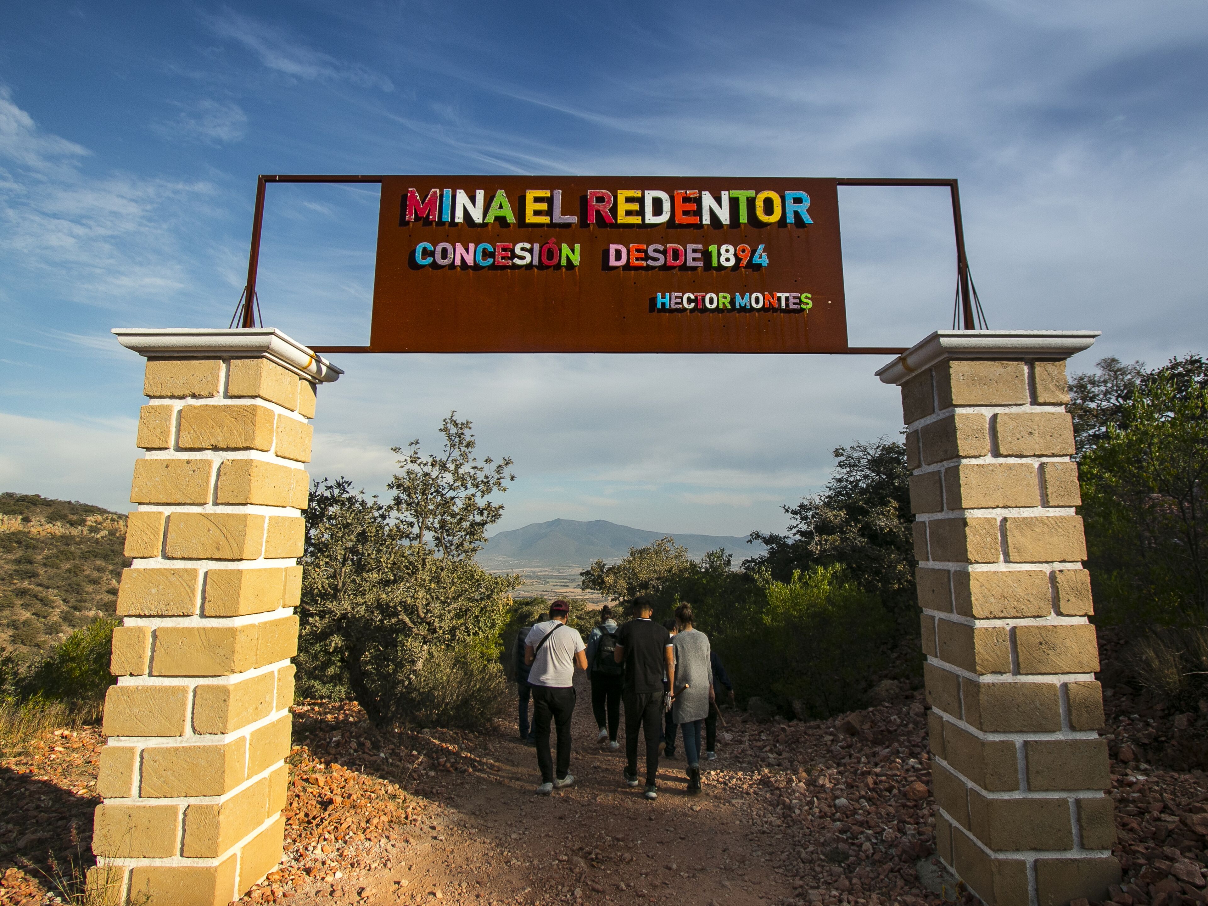 A sign for 'Minael Redentor Concesión' with a view of a mountainous landscape.