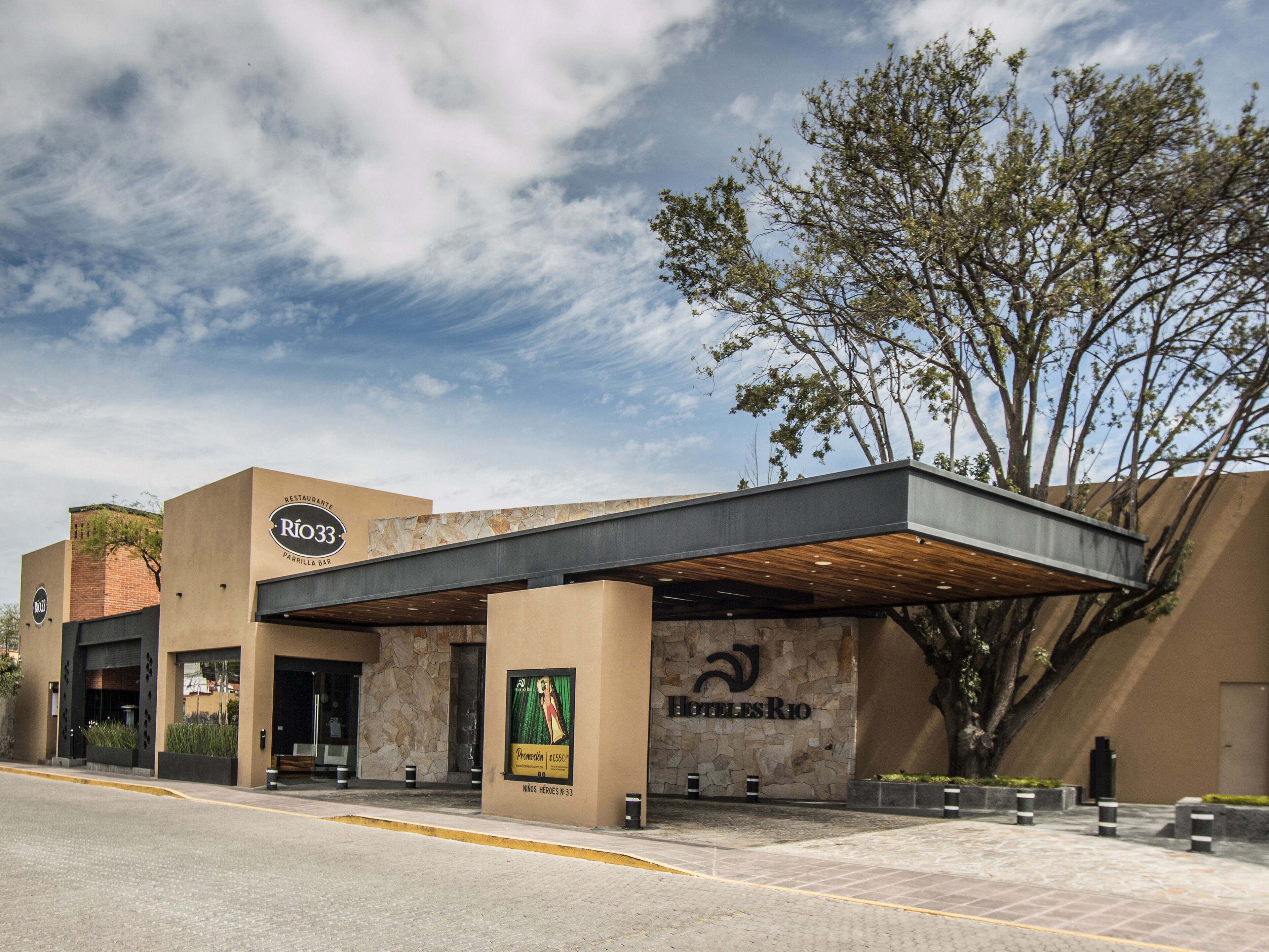 A hotel with a modern facade, a covered entrance, and a prominent sign for 'Hotel Rio'.