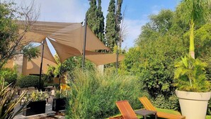 A garden with a shaded seating area, a small water feature, and a variety of plants. - Hotel Rio Tequisquiapan (Tequisquiapan)