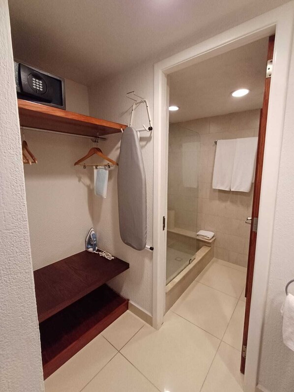 Un baño con ducha, lavabo y toallero.