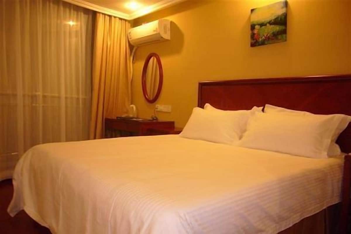 Ein ordentlich bezogenes Bett mit weißen Leinen in einem Hotelzimmer.