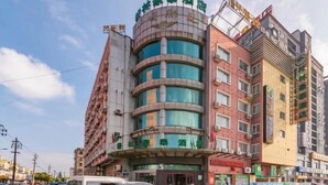 A multi-story hotel with a curved facade, multiple balconies, and a prominent sign at the top. - Greentree Inn Yancheng Dafeng Hotel (Yancheng)