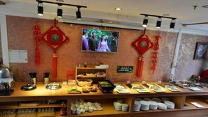 A buffet area with various food items and dishes displayed on shelves. - GreenTree Inn Shanghai Chongming Bao Town Express Hotel (Shanghai)