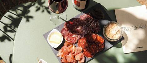 A round table with a variety of food items including cheese, olives, bread, and a bottle of wine.