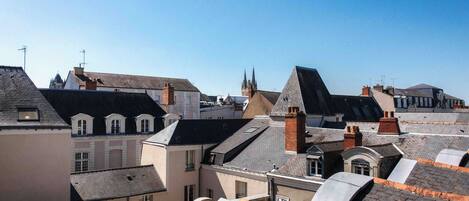 Vista de un pueblo con varios edificios, incluyendo una iglesia con una aguja alta y varias edificaciones residenciales con diferentes estilos de tejado.