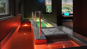 A modern spa area with a heated floor, a small pool, and a seating area with a view of greenery. - Hotel San Giorgio  Heaven Spa (Fiuggi)