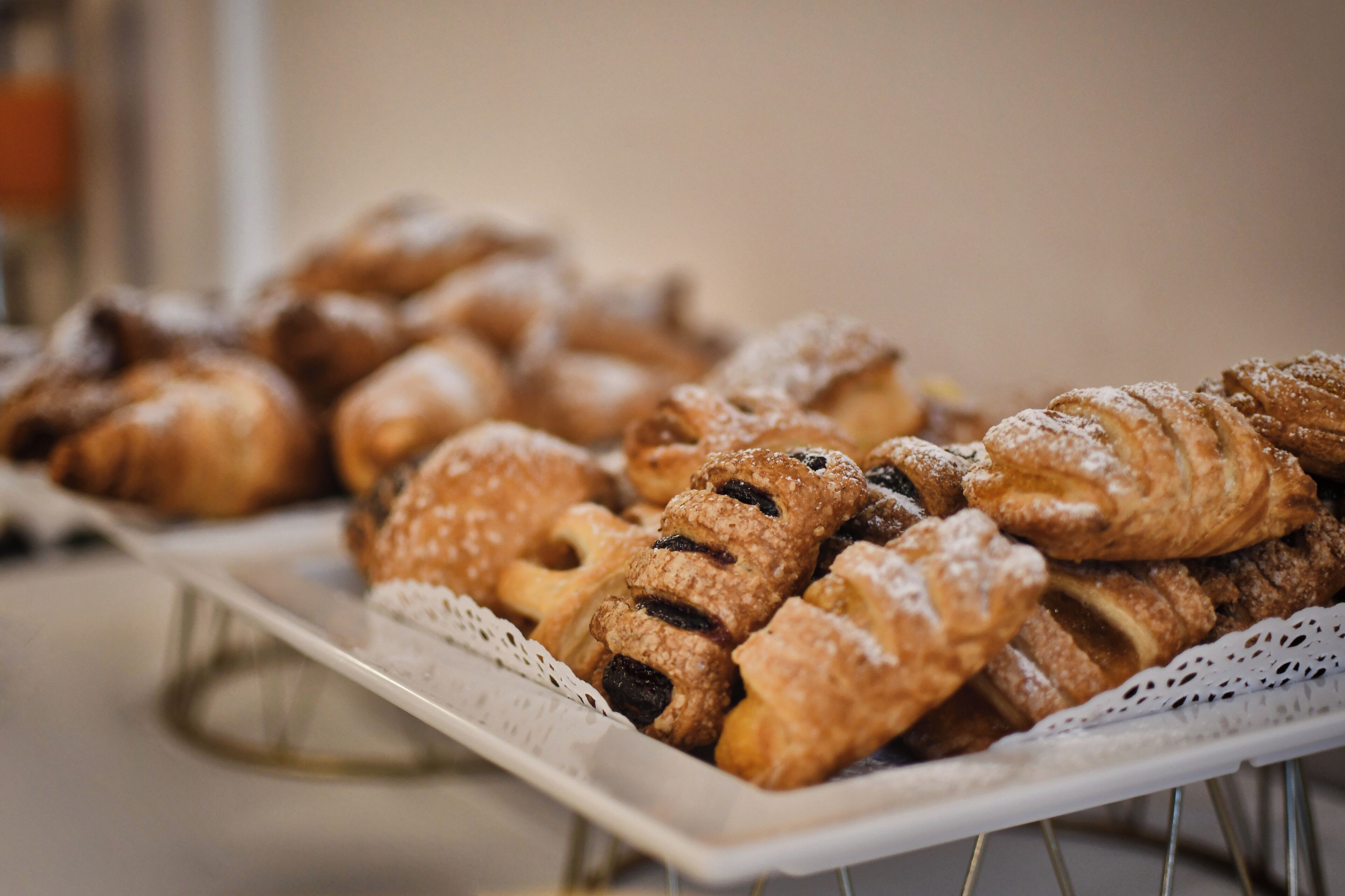 A tray of assorted pastries, including croissants and other baked goods, arranged on a white plate.