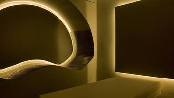 Un intérieur moderne avec un mur incurvé en guise d’élément décoratif et un banc.
