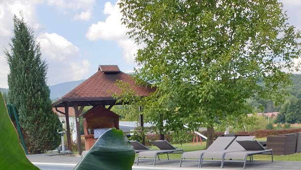 A pool area with lounge chairs, a gazebo, and large green foliage. - House Tina - Bed and Breakfast (Rakovica)