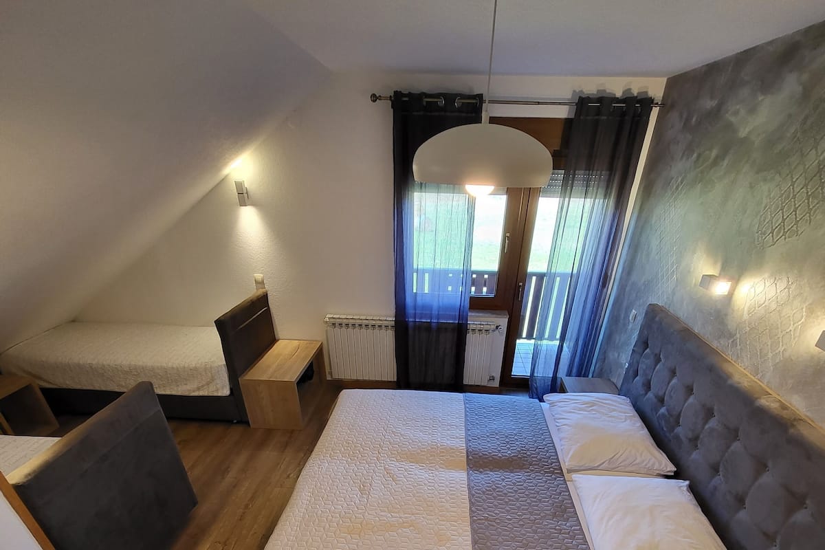 A bedroom with a large bed, a desk, and a chair.