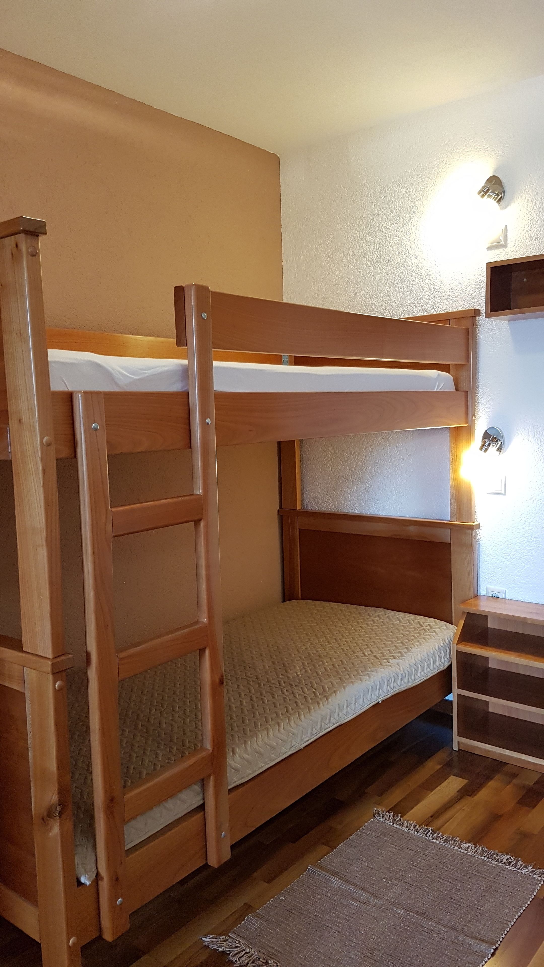 A bunk bed with a wooden frame and a mattress.