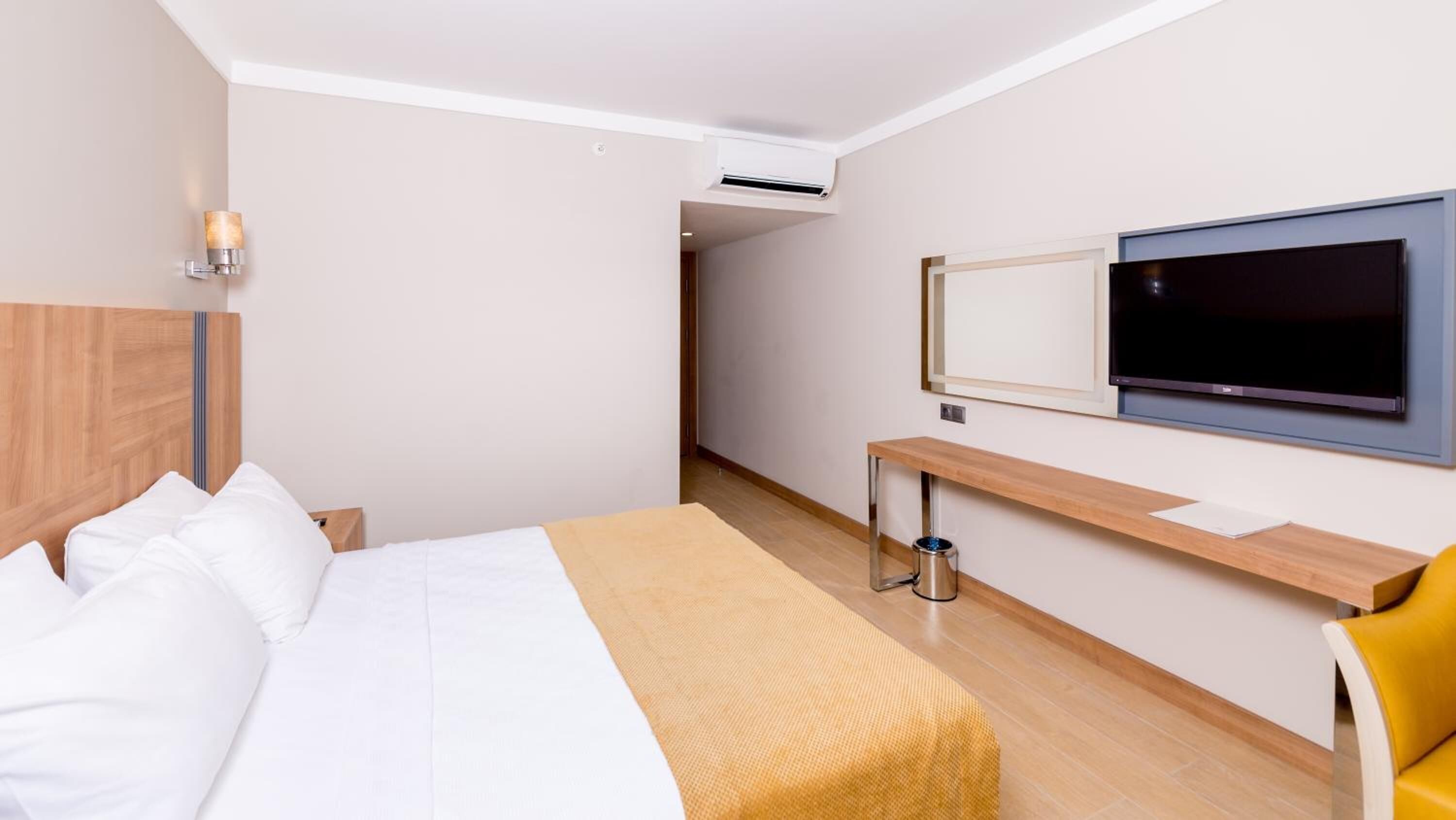 Una habitación de hotel con cama, televisión, escritorio y silla.