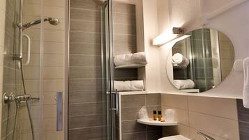 A modern bathroom with a glass-enclosed shower, a sink, and a mirror.
