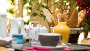 Una mesa de desayuno con pan, una jarra de jugo de naranja y una taza.