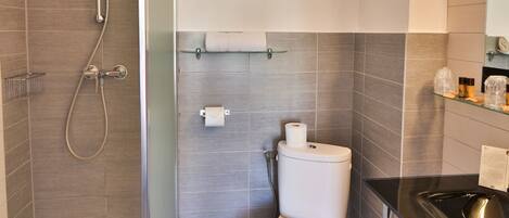 Un baño moderno con ducha, inodoro y lavamanos.