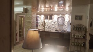 Un vestíbulo de hotel con pared de piedra, un reloj y una recepción.