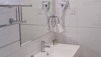 Ein modernes Badezimmer mit Waschbecken, Spiegel und Handtuchhalter.