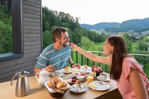 A dining table with breakfast items and a view of a green landscape. - Goldener Adler Oberried - Hotel & Appartements (Oberried)