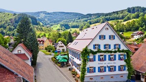 A traditional European building with a sloped roof, multiple windows with shutters, and a sign indicating it is a restaurant. - Goldener Adler Oberried - Hotel & Appartements (Oberried)
