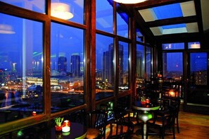 A high-rise building with large windows overlooking a cityscape at night. - Hotel Monec (Ankara)