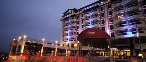 A multi-story hotel with balconies and a covered entrance area.