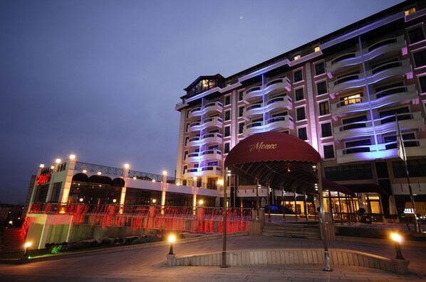 A multi-story hotel with balconies and a covered entrance area.