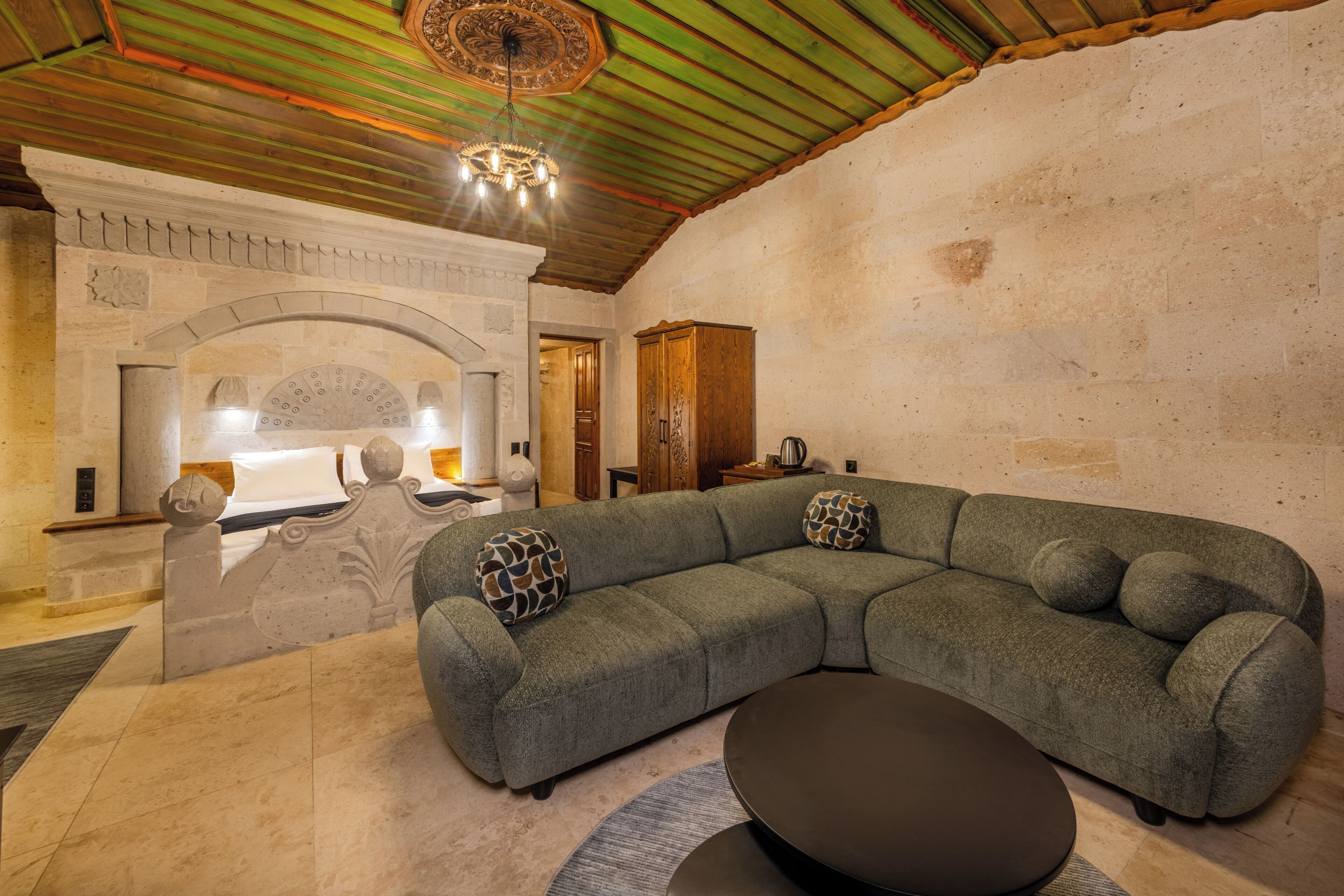 Una sala de estar moderna con un sofá modular, una mesa de centro redonda y una chimenea.