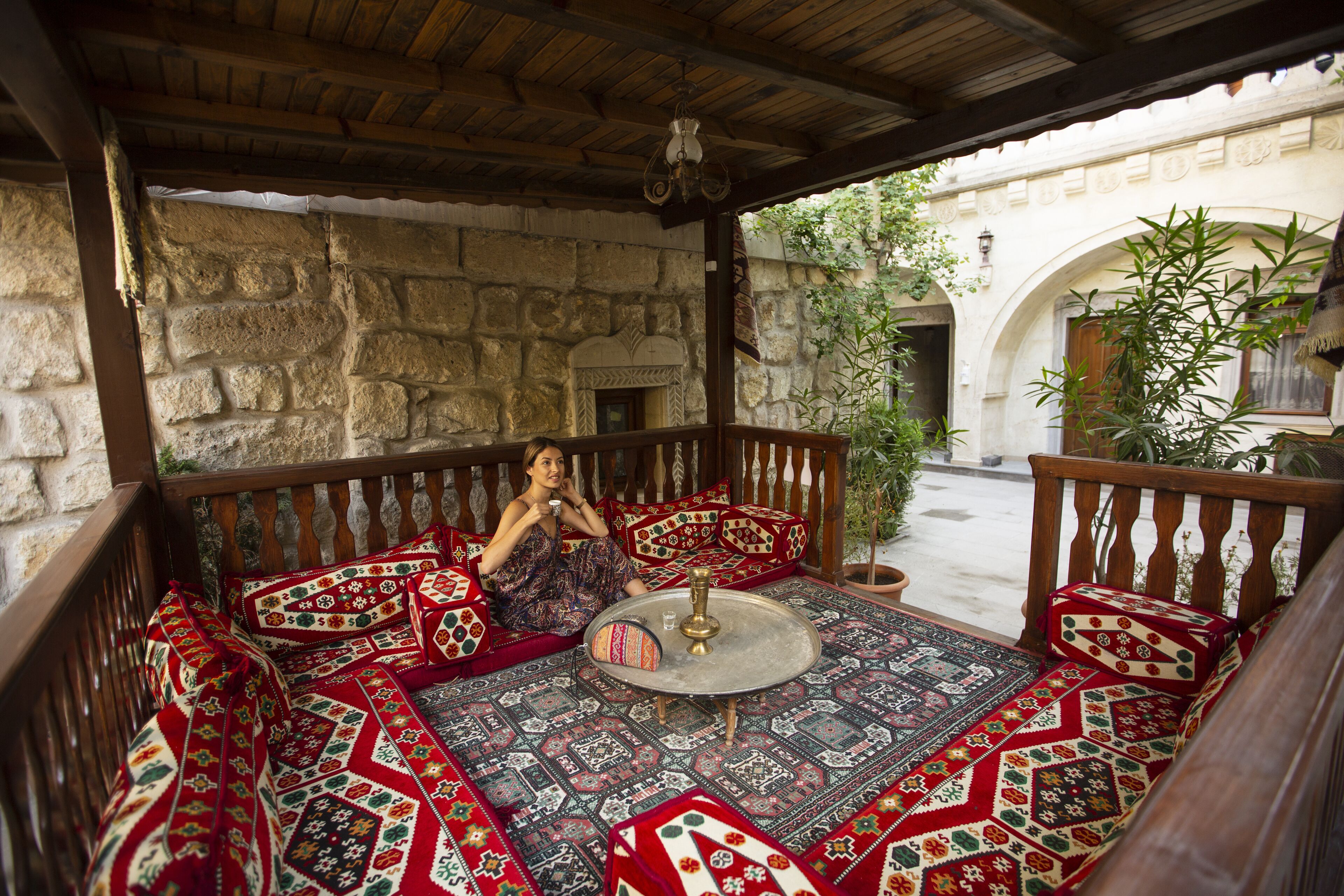 A traditional room with a stone wall, a wooden ceiling, and a patterned floor.