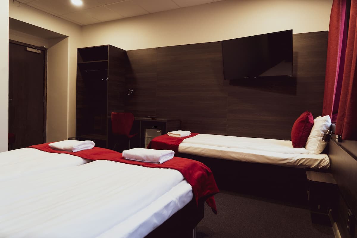 Chambre Triple, salle de bains privée | Minibar, bureau, rideaux occultants, lits pliants/supplémentaires