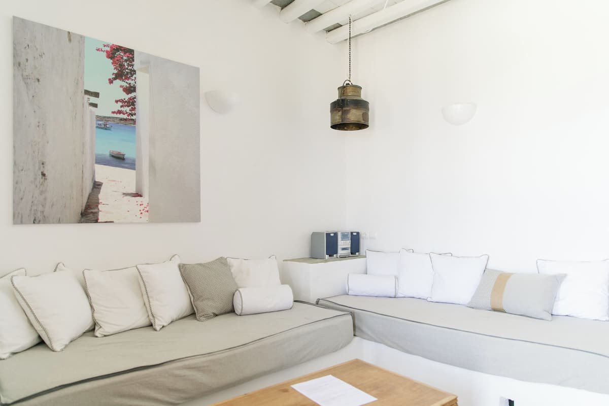 Ein modernes Wohnzimmer mit einer Couch, einem Couchtisch und einer Pendelleuchte.