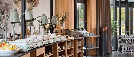 A buffet area with a variety of food items, a coffee station, and a seating area with tables and chairs.