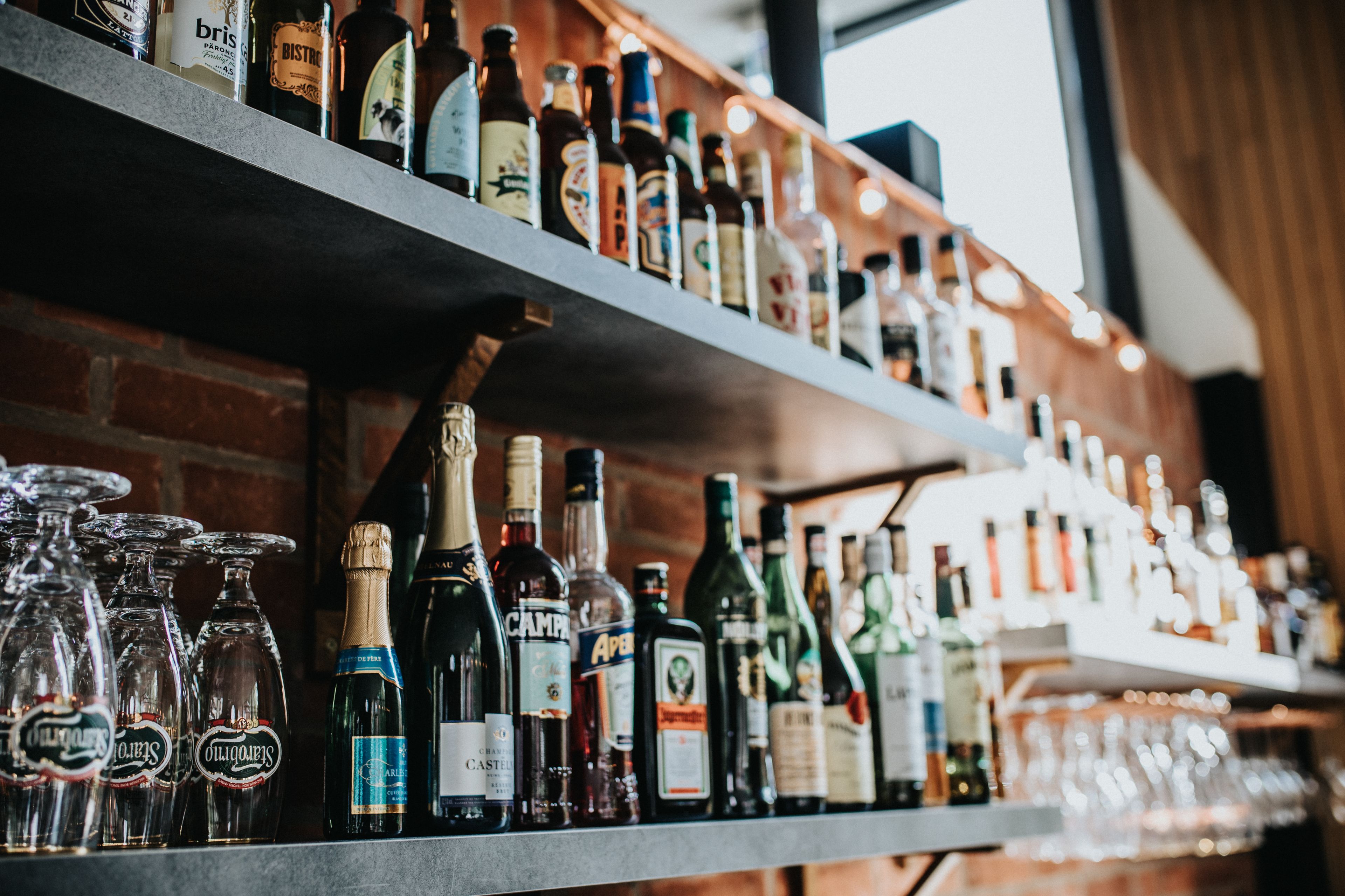 A bar with shelves of various liquor bottles and glasses.